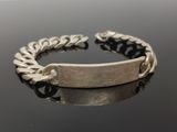 bracelet argenté et noir avec une chaîne sur un fond noir