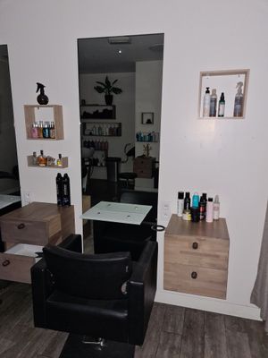 une photo d'un salon de coiffure avec un fauteuil et un miroir