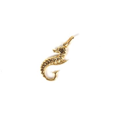 un pendentif en forme d'hippocampe doré sur fond blanc