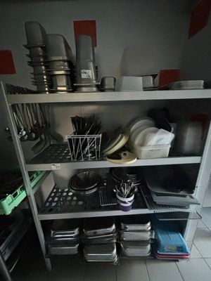 une étagère de cuisine sur laquelle sont posés de la vaisselle et des ustensiles