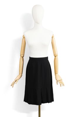 un mannequin vêtu d'un haut blanc et d'une jupe noire