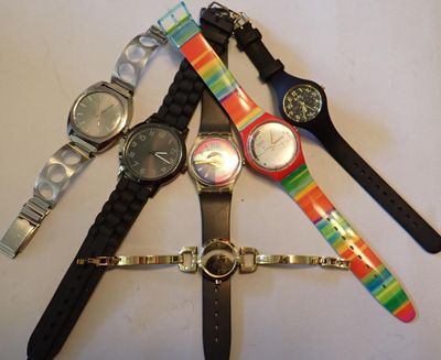 plusieurs montres de différentes couleurs empilées les unes sur les autres sur une table