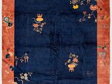 a blue and orange oriental rug with flowers and birds
