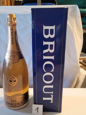 une bouteille de brut posée à côté d'une boîte sur une table