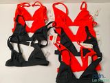 une paire de combinaisons de lingerie rouges et noires posées sur une table blanche