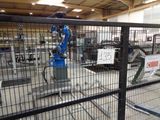 a blue robot that is in the middle of a factory