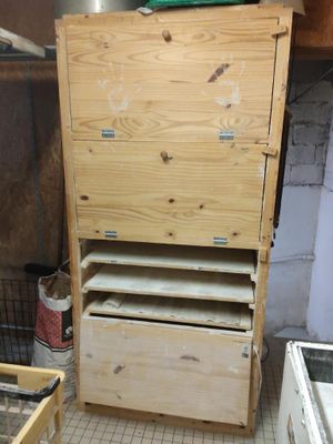 une commode en bois dans une pièce au sol carrelé