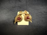 a pair of gold tone earrings with garnets