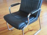 a black leather chair sitting on a hard wood floor
