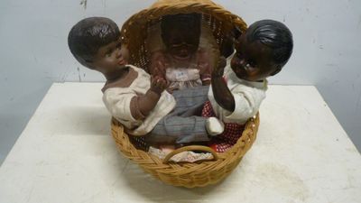 une figurine représentant trois enfants dans un panier posé sur une table