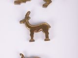 trois broches en métal doré représentant des animaux, sur fond blanc