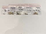 three bags of small metal animals sitting on top of a white surface