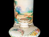 a white vase with a painting on it sitting on a table