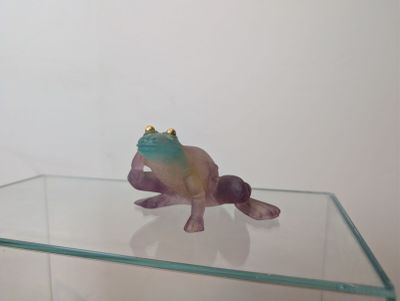 a glass table with a figurine of a frog on top of it
