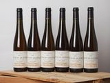 six bouteilles de vin sont posées dans une caisse en bois sur une table