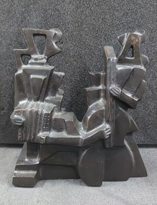 a metal sculpture of a man and woman sitting on a motorcycle