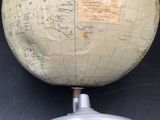 a large globe on a stand on a black surface