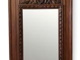 a large mirror with a wooden frame and a decorative design