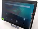 someone is holding a tablet computer in their hand on a white surface