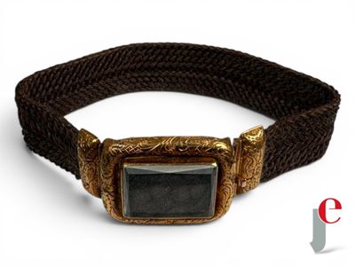 une photo d'un bracelet en or orné d'une pierre noire