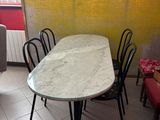 a table and chairs in a room with a yellow wall
