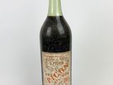 an old bottle of wine sitting on top of a white surface