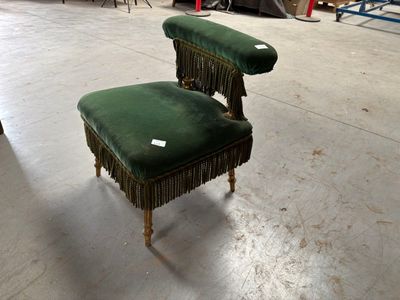 deux chaises vertes ornées de franges dans un entrepôt