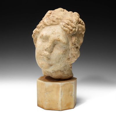 une tête de femme antique en marbre posée sur un socle