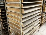 de nombreux plateaux en bois empilés les uns sur les autres dans une pièce