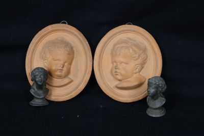 pair of bronze busts of a boy and a girl on a black background