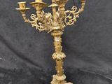 an ornate brass candelab with five candles on a stand
