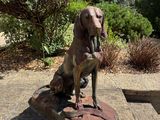 une statue représentant un chien assis sur un bloc de pierre