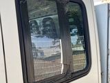 a white van that is parked next to a fence