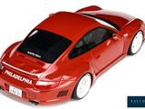 a red toy car that is sitting on a white surface