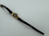 an image of a black and gold watch on a white surface