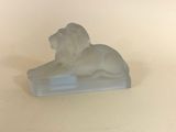 une statue de lion blanc posée sur une surface blanche