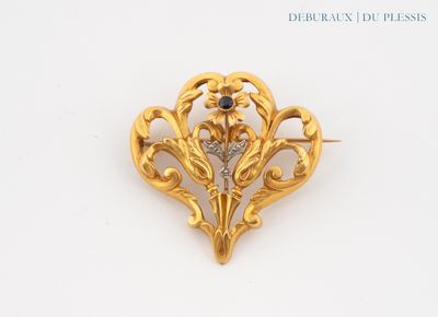 an image of a gold brooch with a blue stone in the center