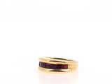 a close up of a ring with a red stone in it