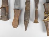 many different types of knives hanging on a wall