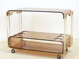 a glass and brass trolley with two shelves on it