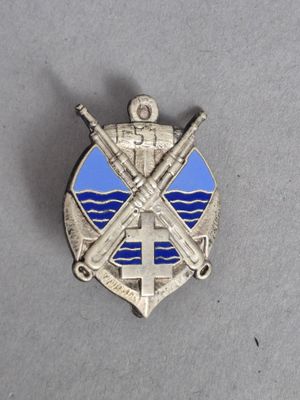insigne représentant des épées croisées et une croix, sur un fond gris