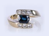 an image of a blue and white diamond ring on a white surface