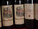 several bottles of red wine are lined up on a shelf