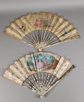 une paire d'éventails anciens peints à la main sur un mur gris