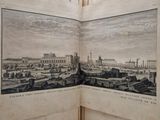 an open book with a picture of a city in it