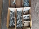 several boxes of screws and nuts are sitting on the floor