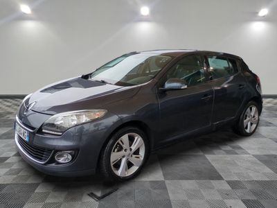 La voiture grise est garée dans le garage, sur le sol à damier.