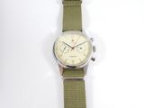 an image of a wrist watch with a green strap on a white surface