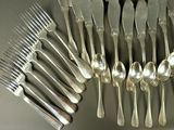 a lot of silver spoons and forks on the table