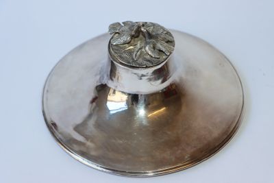 un bougeoir en argent posé sur une table blanche